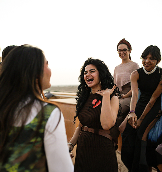 A speaker addressing a small circle of guests at golden hour